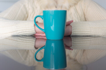Woman drinking coffee on table with reflection