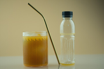 Fresh orange juice in glass pour from plastic bottle