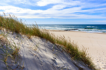 Grass sand dunes and beautiful white sand beach with blue sea near Kolobrzeg, Baltic Sea coast, Poland