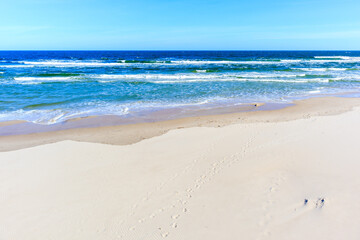 Fototapeta na wymiar Beautiful white sand beach and blue sea near Kolobrzeg, Baltic Sea coast, Poland