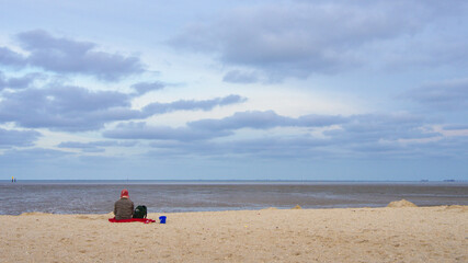 Fototapeta na wymiar Einsame Frau mit Hund am Strand