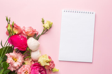 Obraz na płótnie Canvas Notebook and pink flower bouquet on pastel background