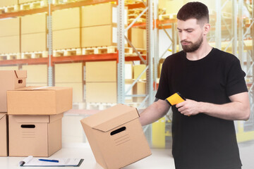 Warehouse inventory. The man checks the availability of the product in the warehouse. Recalculate the product using a barcode reader. Check the availability of goods.