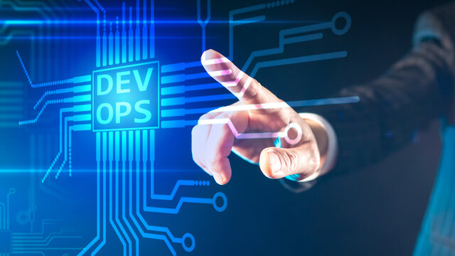 DevOps concept. A person puts their finger on a touch screen that says DevOps. The concept of flexible Devops software development. Interaction of technical specialists.