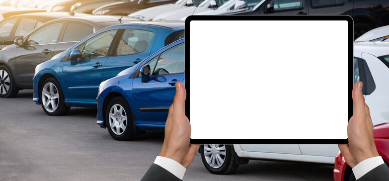 Hands with digital tablet on a background of rows of cars. Car sales.	