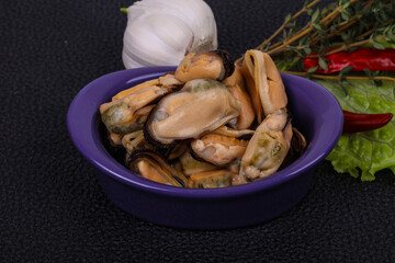 Pickled mussels in the bowl served pepper, garlic and salad