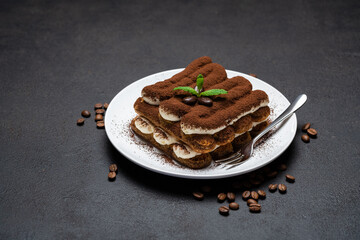 Classic tiramisu dessert on ceramic plate on concrete background