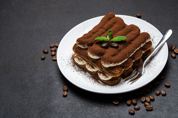 Classic tiramisu dessert on ceramic plate on concrete background