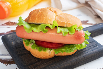 Hot dogs on a wooden Board. Hot dog with lettuce tomato and sausage. Copy space.