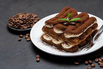 Classic tiramisu dessert on ceramic plate on concrete background
