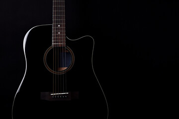 Black acoustic guitar studio shot on black background with copyspace, Guitar is favorite music...