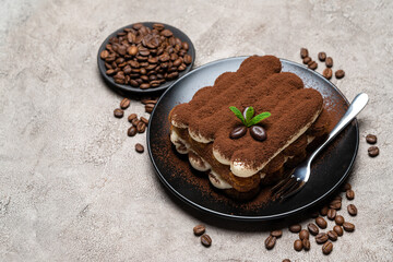 Classic tiramisu dessert on ceramic plate on concrete background