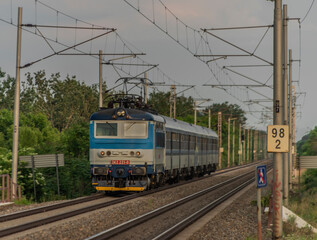 Fototapeta na wymiar Electric blue engine and coaches on fast railway in south of Moravia