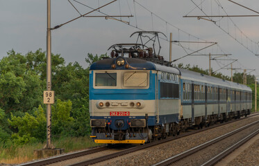 Electric blue engine and coaches on fast railway in south of Moravia