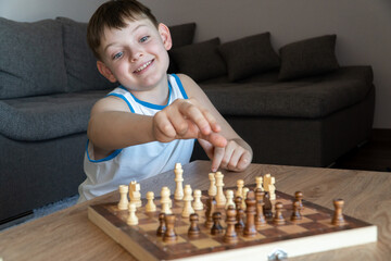 Cheerful child plays chess. A fun game with children in chess