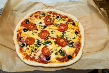 Italian pizza on baking paper. freshly baked pizza.