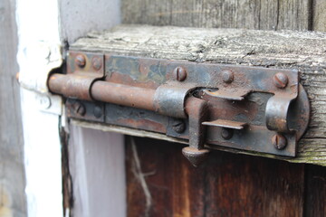 old rusty lock on a wooden door facing down depicting unlocking of lockdown due to coronavirus and covid 19