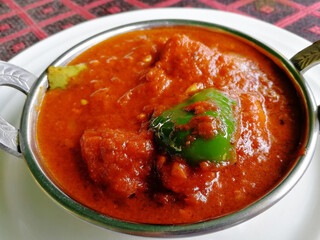 Chicken Tikka masala in kadai on a white plate close-up. Delicious spicy Indian chicken dish
