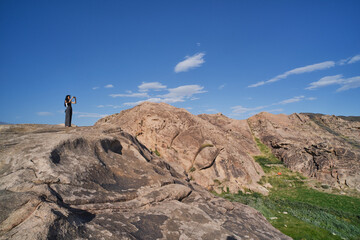 Naklejka premium Asian girl taking picture of landscapes of rocks
