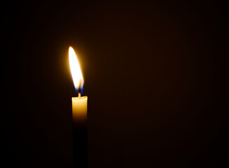 burning candle in the dark , a single candle is lit. 