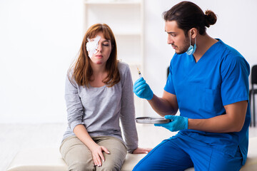 Obraz premium Young head injured woman visiting young male doctor