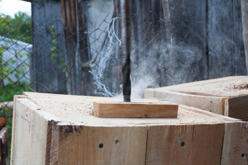 drilling a hole in a wooden  plank