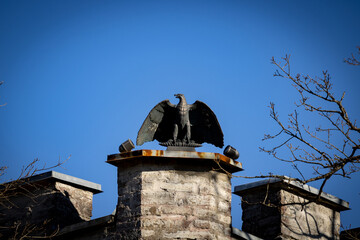 Iron statue towering on the roof of the castle under an open blue sky