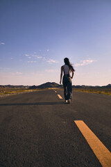 Obraz premium Asian girl walking along the road in between mountains.