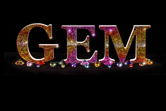 glitter gem letter and gem stones with construction of gem in black background with copy space