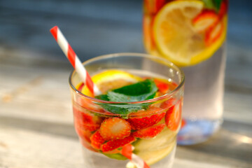 Fresh strawberry cocktail in glass with drinking straw. Glass of strawberry soda drink on wooden table. Summer refreshing punch.