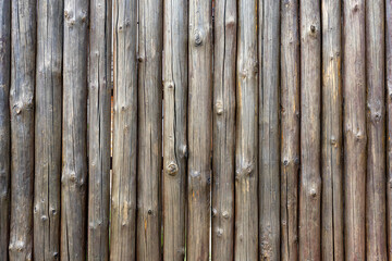 Fence with small wooden trunks. The wooden fence is outdated. Background