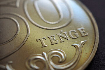 Translation of the inscription: «tenge». Fragment of a Kazakh coin in 50 tenge. The name of the currency in close-up in Latin. Coin sample 2019. Illustration on the theme of economy of Kazakhstan