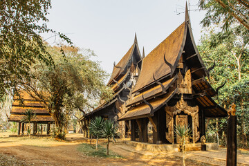 Black Temple in Chiang Rai,Thailand.Popular tourist place.Wooden house gold facade.Carved painted wood.Thai style house decor
