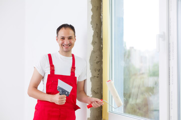Repair in the slopes of the window. The process of applying a layer of plaster on the sides of the...