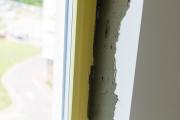 Repair in the slopes of the window. The process of applying a layer of plaster on the sides of the...