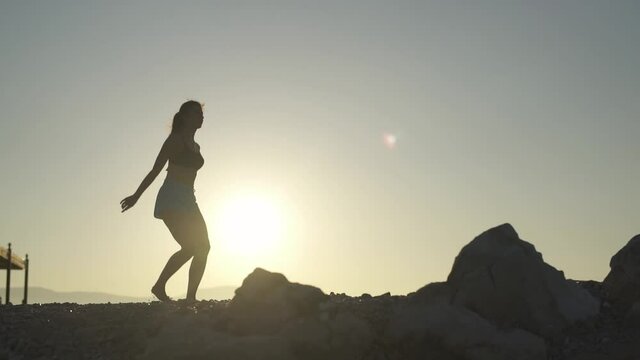 Beautiful girl doing fuette on the beach. Sea, sunrise, beach, woman.