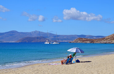 Couple enjoying beach holiday on the coast of Naxos island in Greece.