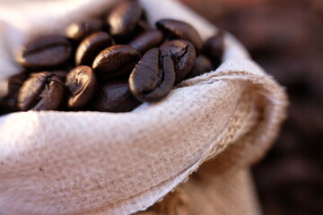 close up coffee beans and coffee cup on wood table background and space