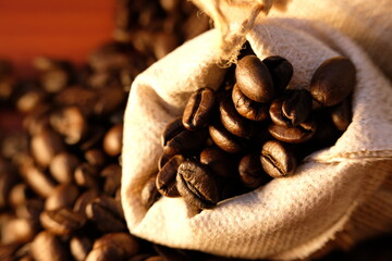 close up coffee beans and coffee cup on wood table background and texture