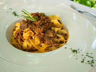 Traditional Italian pasta. Plate of tagliatelle with meat sauce. Tagliatelle al ragù. White ragu.