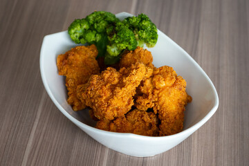 Fried chicken super crispy close up home made bow no brands with broccoli. Tasty and spicy unhealthy food