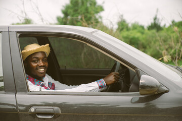 Fototapeta na wymiar African man driver smiling while sitting in a car with open front window