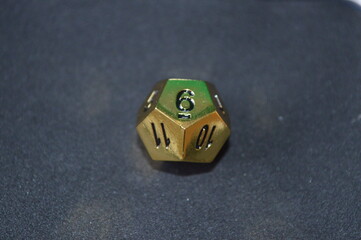 Gold metallic d12 twelve sided dice on foam surface