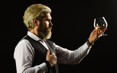 Matured in sherry casks. Whisky tasting. Bearded businessman in elegant suit with glass of whisky....