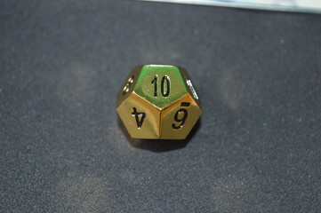 Gold metallic d12 twelve sided dice on foam surface