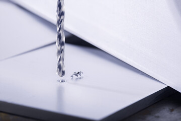 metal drill bit make holes in aluminum billet on industrial drilling machine with shavings. Metal...