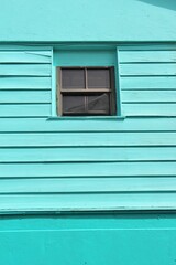 Fototapeta na wymiar turquoise blue painted house in Antigua caribbean, background with teal turquoise window of hut house 