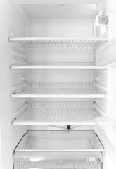 Empty open white fridge. Defrosted refrigerator without food.