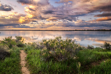 Dramatic Storm Clouds over a calm lake at sunrise