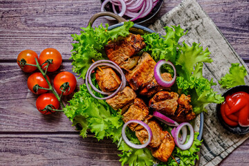 Skewers of Meat with sauce on wooden cutting board, ready to be served as summer party meal, view from above.